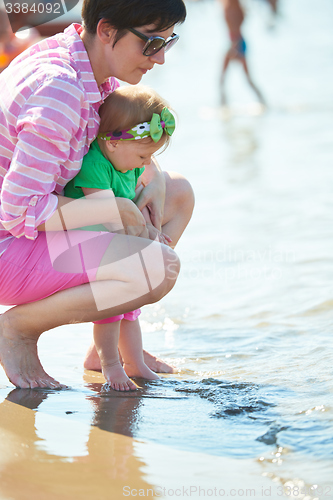 Image of mom and baby on beach  have fun