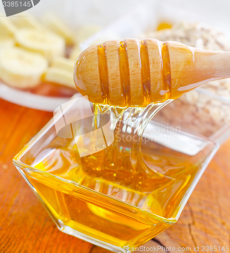 Image of Honey in the glass bowl on the wooden table