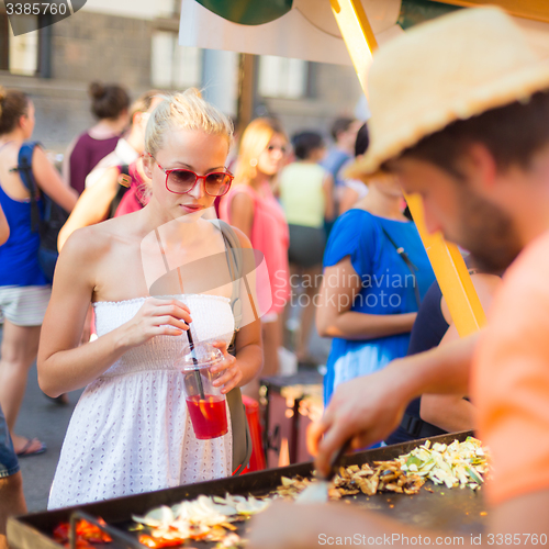 Image of Woman buying a meal at food market.