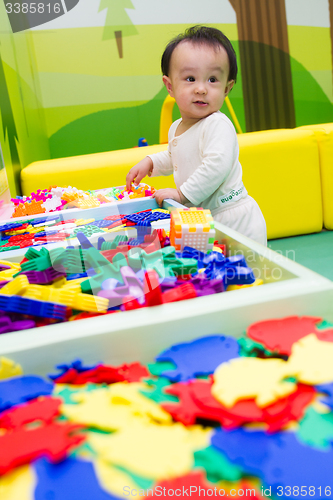Image of Chinese baby playing puzzle
