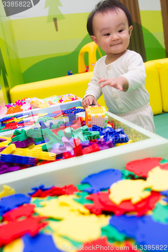 Image of Chinese baby playing puzzle