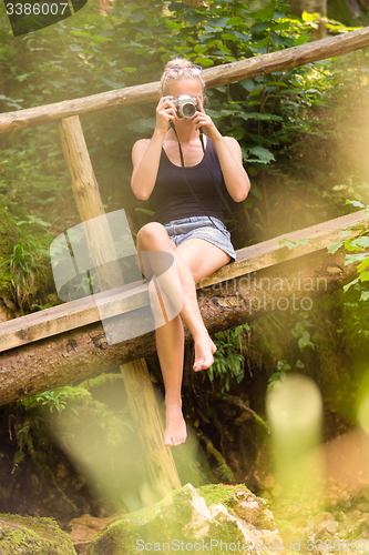 Image of Woman in nature with retro camera.