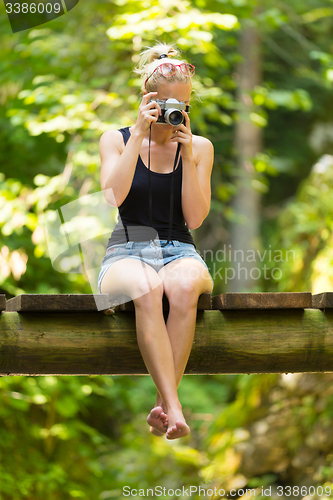 Image of Woman in nature with retro camera.