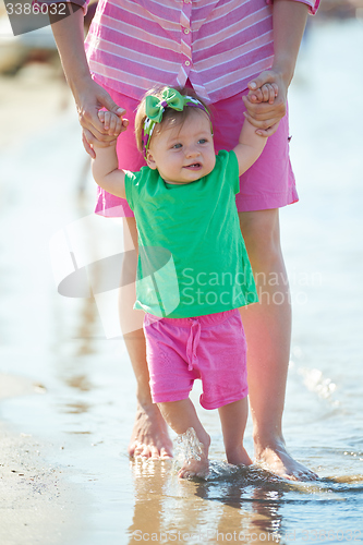 Image of mom and baby on beach  have fun