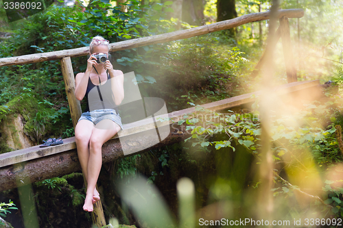 Image of Woman in nature with retro camera.