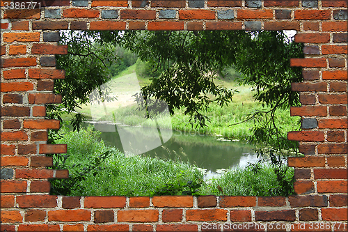 Image of hole in the brick wall and view to summer river