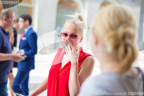 Image of Female friends gossiping on a street.