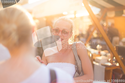 Image of Female friends enjoying a conversation on market.