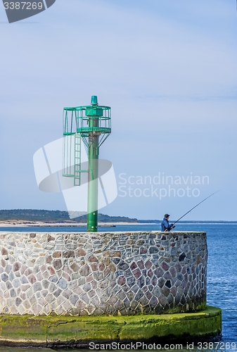 Image of Fishing man at the entrance of the seaport of Ustka, Poland