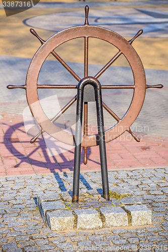 Image of Old wheel of a sail boat in a harbor