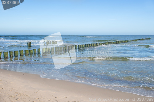 Image of beach of the Baltic Sea with old wooden wavebreakers