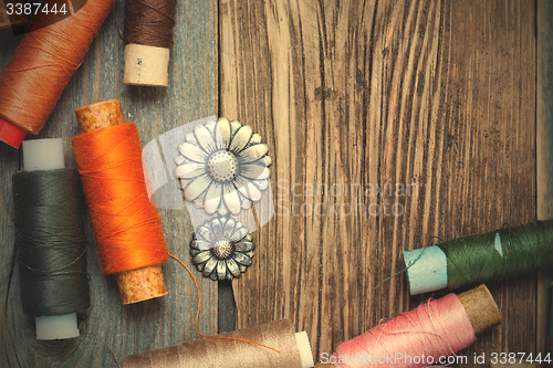 Image of vintage buttons and old reels of varicolored thread