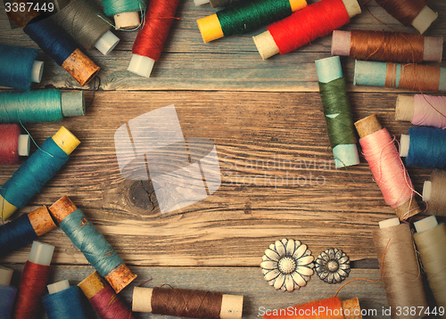 Image of vintage reels of varicolored thread and old flower buttons