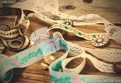 Image of ribbon, lace, tape with embroidery and buttons
