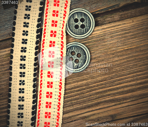 Image of two vintage tape with embroidered ornaments and old buttons