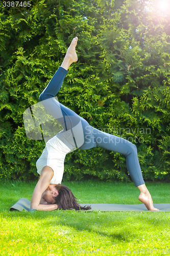 Image of beautiful adult woman doing yoga at summer morning