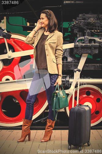 Image of beautiful adult woman traveler on the platform near the old stea