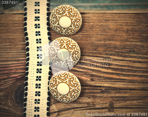 Image of Vintage ribbon with embroidered pattern and three ancient button