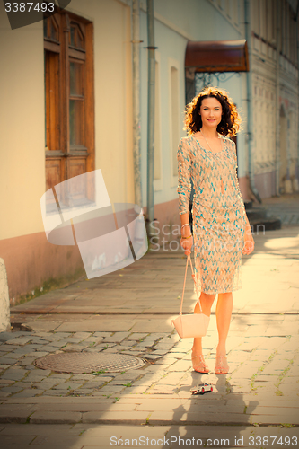 Image of smiling beautiful woman with a small handbag