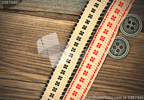 Image of old band with embroidered ornaments and vintage buttons