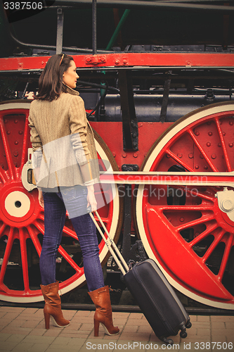 Image of beautiful adult woman traveler with a suitcase