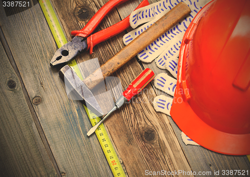 Image of pliers, hammer, screwdriver, measuring tape, gloves and orange h