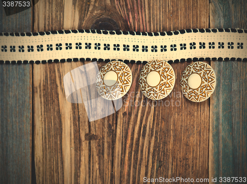 Image of Vintage tape with embroidered pattern and three ancient buttons