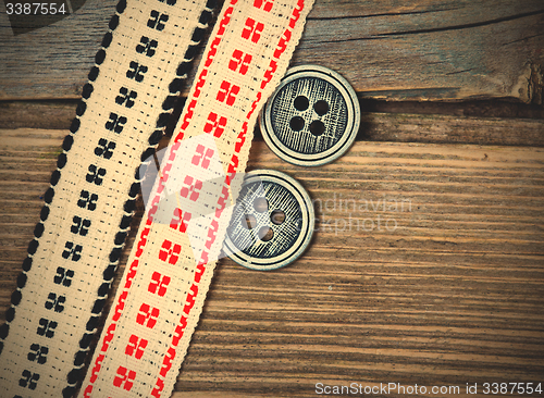 Image of two old ribbons with embroidered ornaments and vintage buttons
