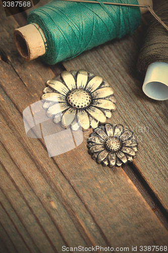 Image of vintage buttons, spools of thread and sewing needle