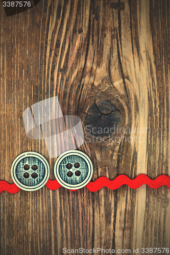 Image of old red tape and two vintage classic buttons