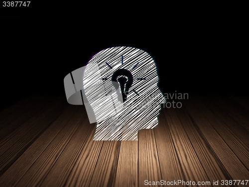 Image of Data concept: Head With Light Bulb in grunge dark room