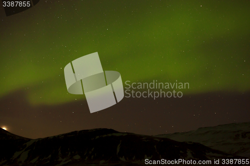 Image of Northern lights with snowy mountains in the foreground