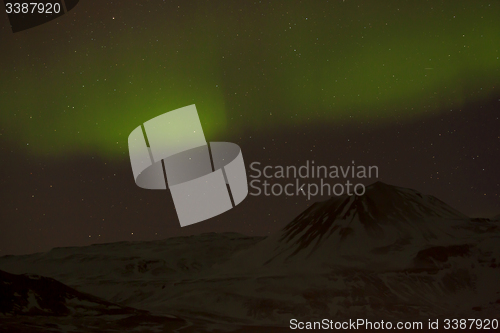 Image of Northern lights with snowy mountains in the foreground