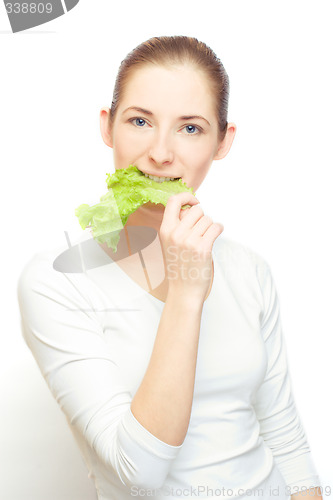 Image of young  woman with lettuce leaf