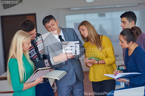 Image of group of students working with teacher on  house model