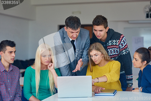 Image of group of students getting suppport from teacher