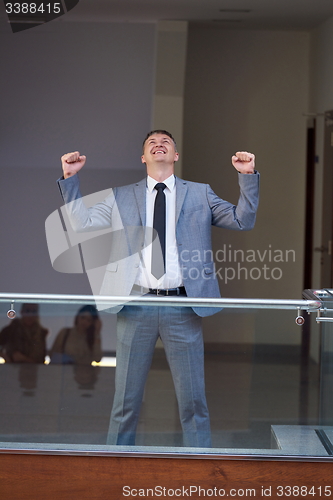 Image of happy business man raise hands from joy