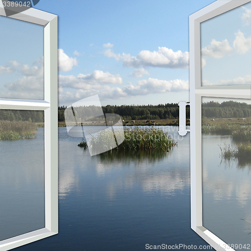 Image of opened window to the summer lake