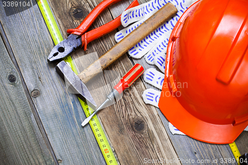 Image of pliers, hammer, screwdriver, measuring tape, gloves and orange h