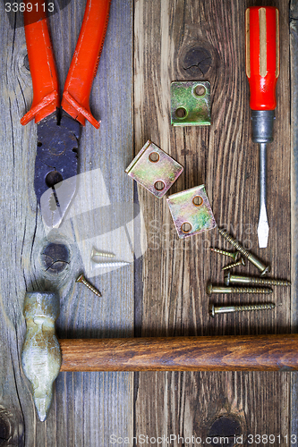 Image of old hammer, pliers, screwdriver old, screws and metal corners