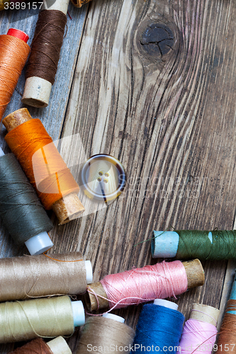 Image of Vintage spools with multi colored threads and old button