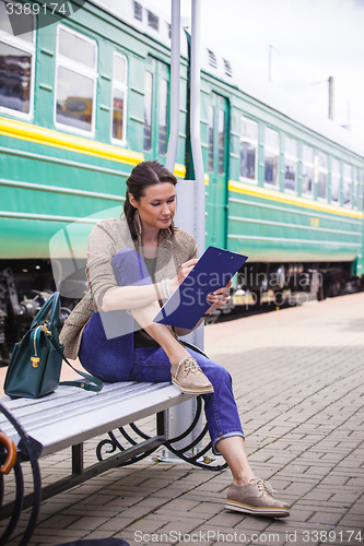 Image of beautiful adult woman takes notes in notepad