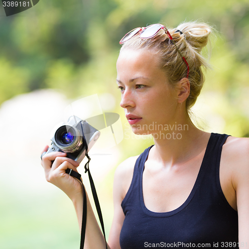 Image of Woman in nature with retro camera.