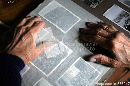 Image of An old woman's hands on an old photo album