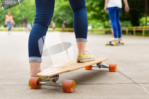 Image of Teenage girl practicing riding long board.