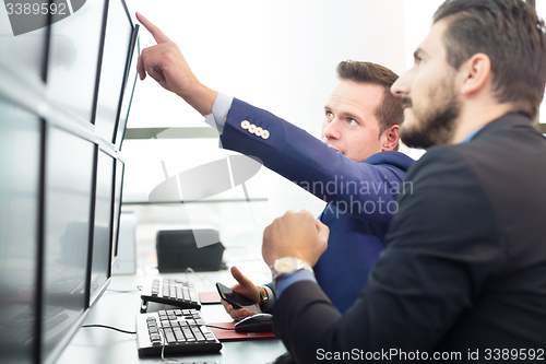 Image of Stock traders looking at computer screens.