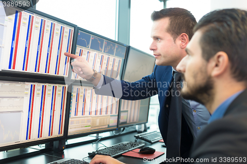 Image of Stock traders looking at computer screens.