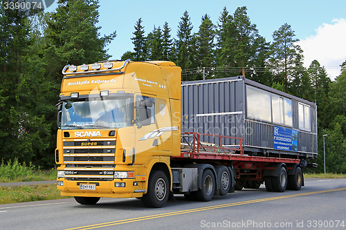 Image of Yellow Scania 164G Truck Hauls Portable Cabin