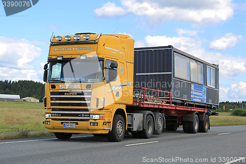 Image of Yellow Scania 164G Truck Hauls Portable Cabin