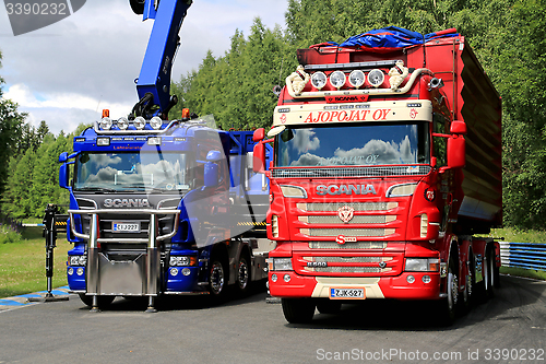 Image of Red and Blue Scania Trucks on Display